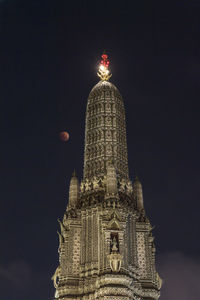 Low angle view of illuminated building against sky at night