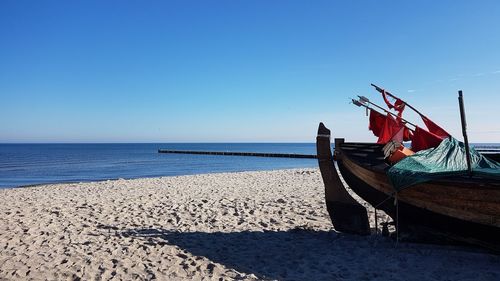 Scenic view of beach against clear blue sky