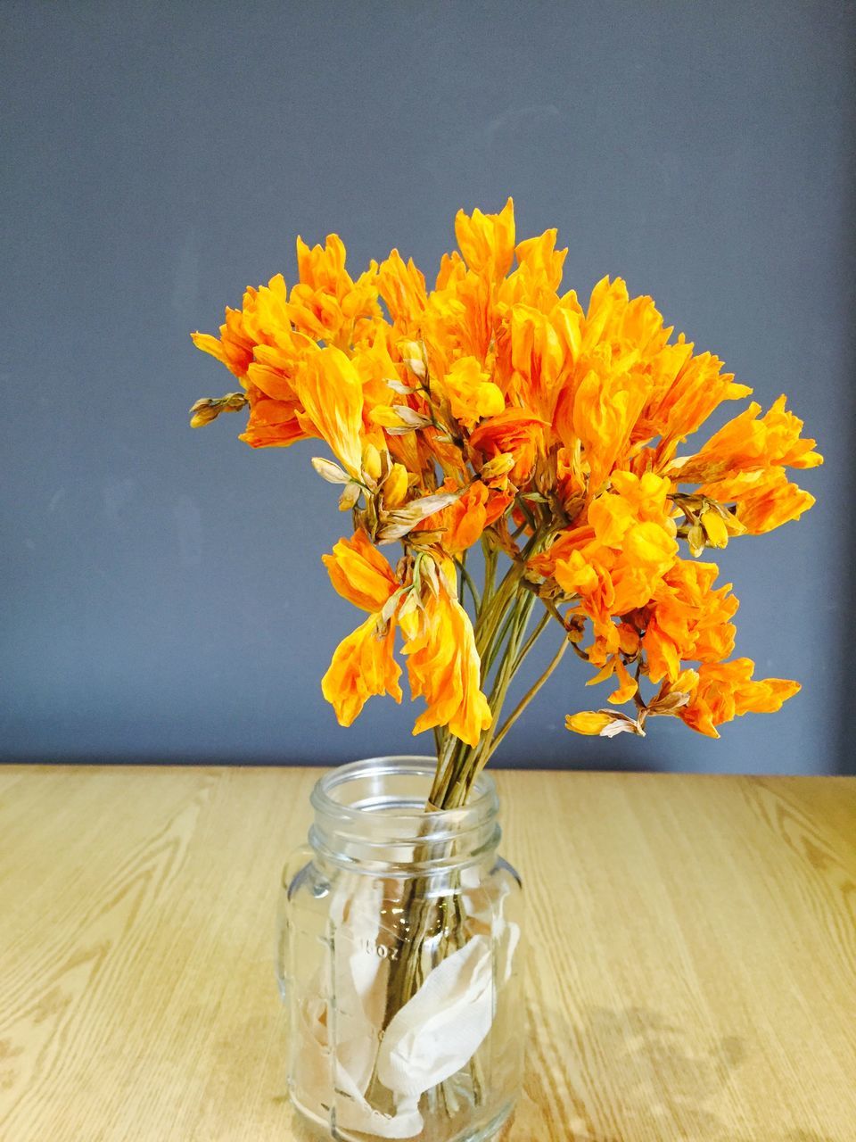 flower, vase, freshness, yellow, table, indoors, fragility, glass - material, petal, close-up, still life, orange color, drinking glass, transparent, flower head, beauty in nature, water, drink, stem, home interior