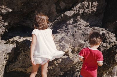 Rear view of children standing on rock