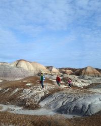 People walking on mountain against sky