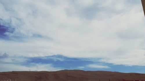 Scenic view of mountains against cloudy sky