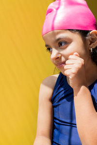 Cute girl looking away against wall