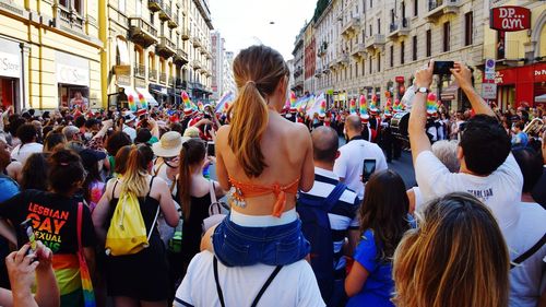 Rear view of people walking on street in city