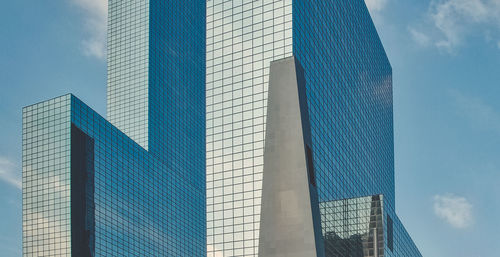 Low angle view of modern glass building against sky