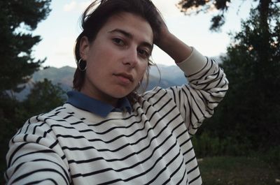 Portrait of woman standing by tree