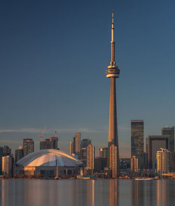 Illuminated buildings in city against clear sky