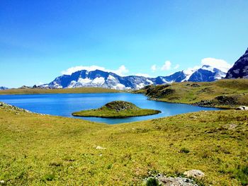 Scenic view of landscape and mountains against clear blue sky