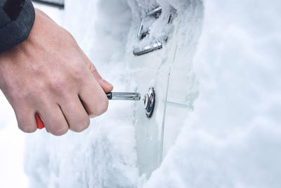 Close-up of person hand holding metal during winter