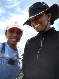 Portrait of smiling young man standing against sky