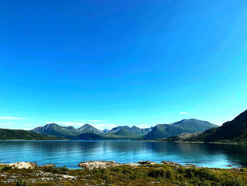 Scenic view of lake against clear blue sky