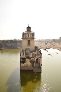 Building by lake against clear sky