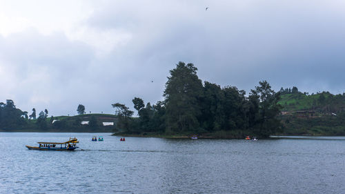 Boats sailing in river against sky