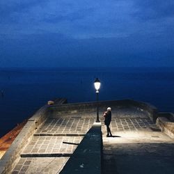 Woman standing by illuminated lighting equipment at observation point