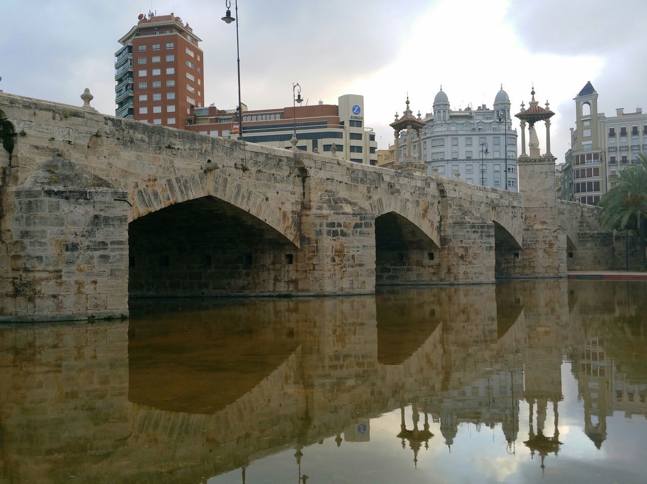 architecture, built structure, building exterior, sky, water, reflection, cloud - sky, waterfront, building, cloud, low angle view, outdoors, no people, river, cloudy, day, residential building, standing water, city, sunlight