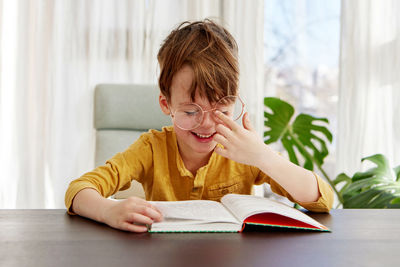 Smart boy reading book and smiling