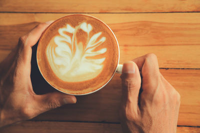 Cropped image of hand holding coffee cup