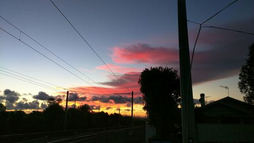 Electricity pylon against cloudy sky