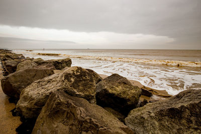 Rocks on beach against sky