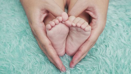 Low section of baby on bed