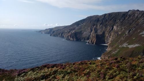 Scenic view of sea and mountains against sky