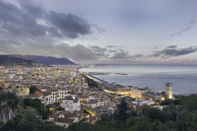 High angle view of town by sea against sky