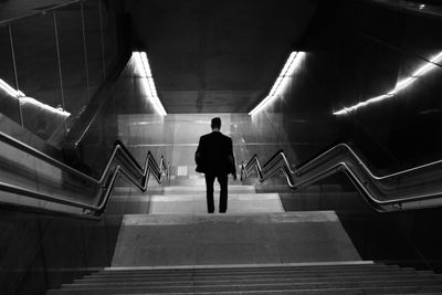 Rear view of man moving down steps