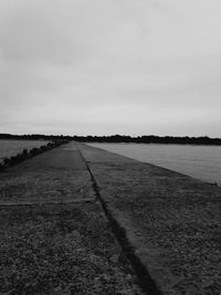 Road by lake against sky