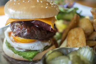 Close-up of burger with pickle on table