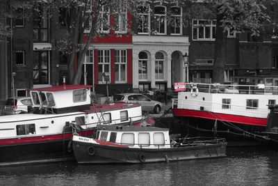 Boats moored in canal along buildings