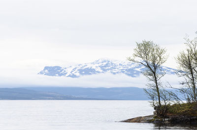 Scenic view of sea and mountains against sky