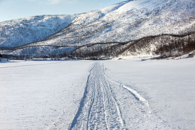 Snow covered field against snowcapped mountain