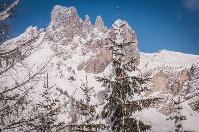 Low angle view of snow covered mountains against sky