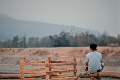 Rear view of man looking at landscape against sky