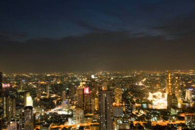 High angle view of illuminated buildings against sky at night