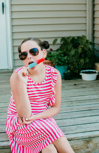 Woman wearing sunglasses sitting outdoors