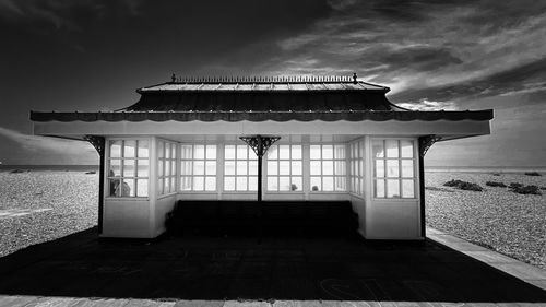 View of building by sea against cloudy sky