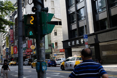 Rear view of people walking on city street