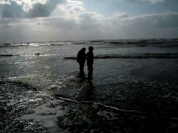 Silhouette of couple standing on beach
