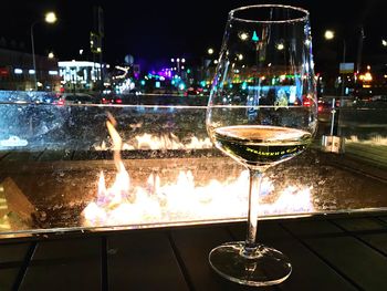 Illuminated wine glass on table at night