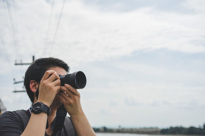 Man photographing against sky