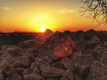 Stack of stones on field during sunset