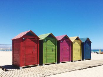 Multi colored umbrellas on beach against clear blue sky