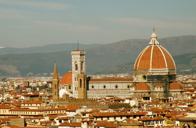 Duomo santa maria del fiore amidst buildings in city against mountains