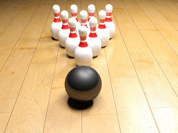 High angle view of bowling balls and pins on wooden floor