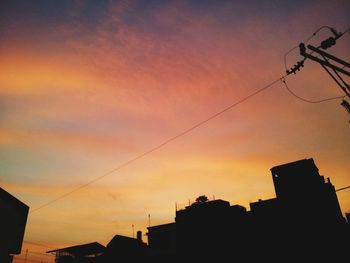 Low angle view of buildings against sky at sunset