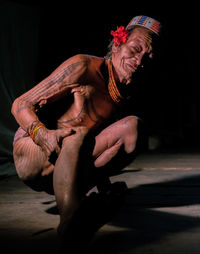 Midsection of man sitting against black background