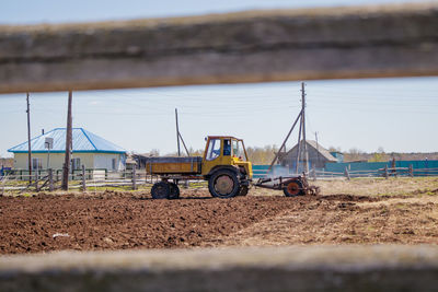 Farmer in tractor preparing land with seedbed cultivator as part of seeding activities in spring.