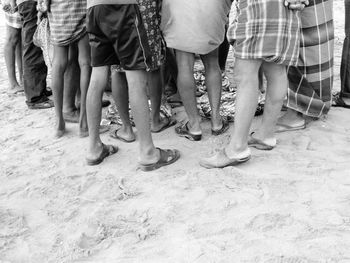 Low section of fishermen standing on beach 