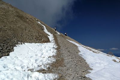 Man on snowcapped mountain against sky